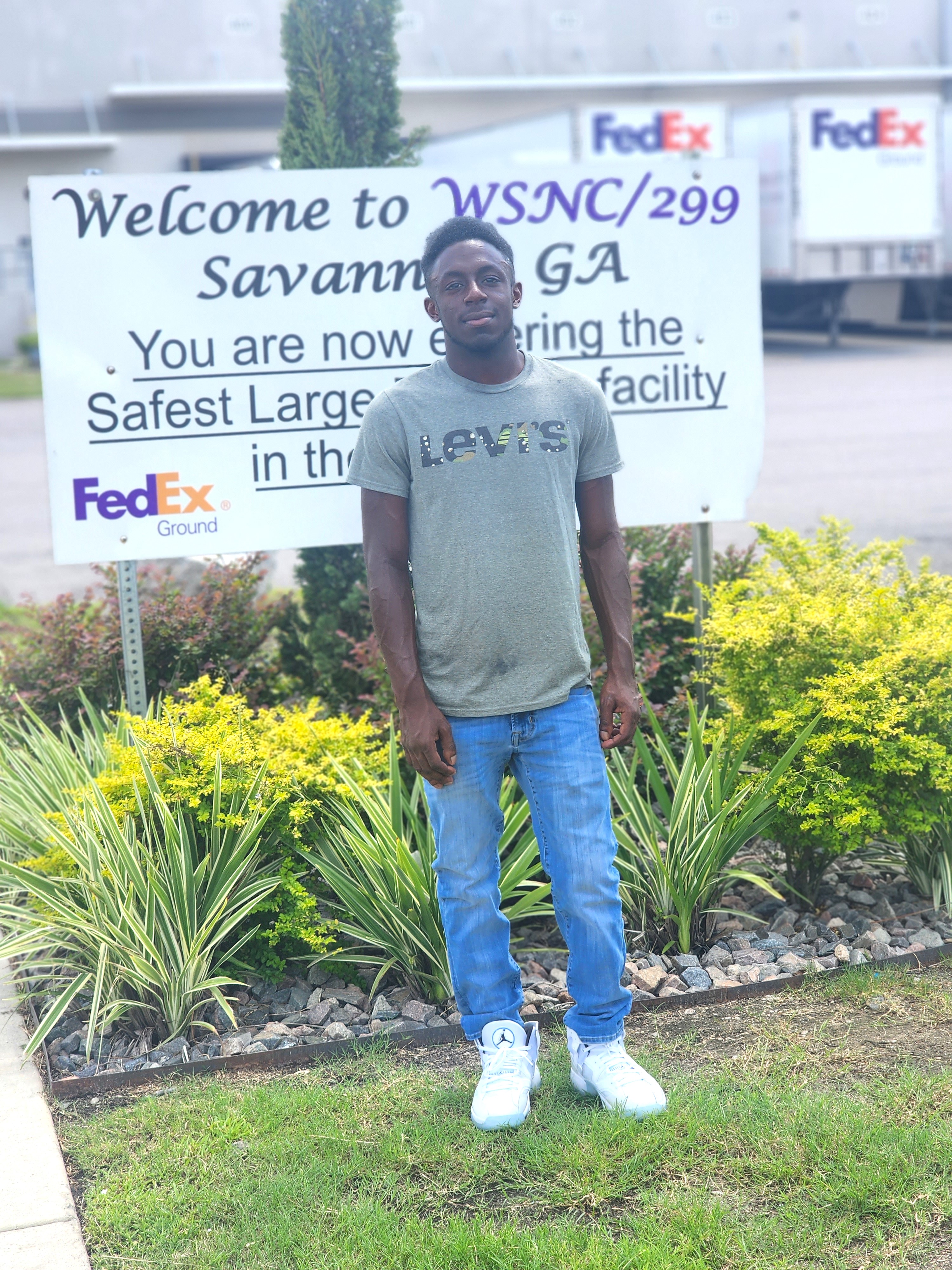Nathan standing in front of a Welcome to FedEx Savannah, GA sign